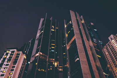 Low angle view of illuminated cityscape against sky at night