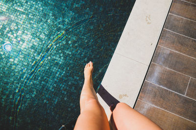 Low section of woman legs in swimming pool