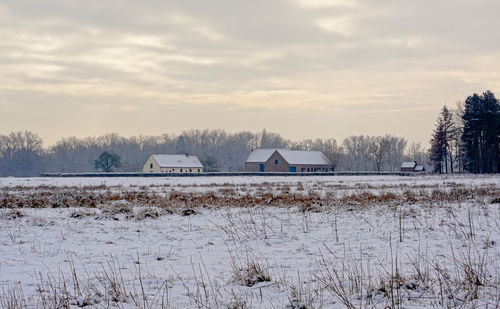 Scenic view of snow covered field against sky