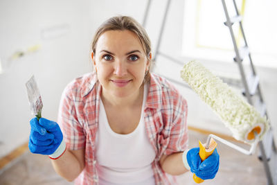 Portrait of young woman drinking water while sitting at home