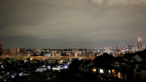 High angle view of illuminated cityscape against sky at night