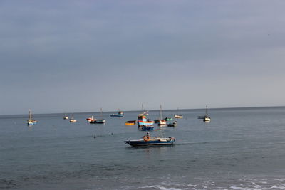 Sailboats on sea against clear sky