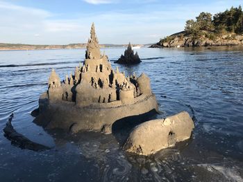 Panoramic view of rocks on beach against sky