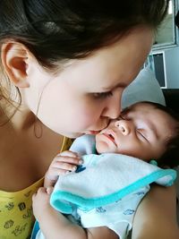 Close-up of mother kissing baby