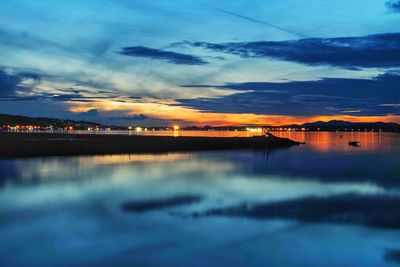 Scenic view of sea against dramatic sky at sunset