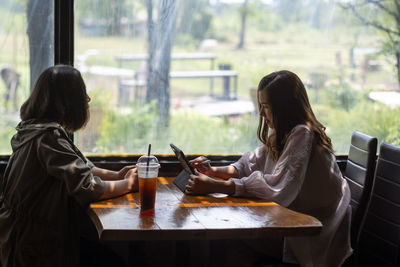 Business women running a business inside a coffee shop, two businessmen meeting inside a building.