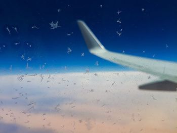 Airplane flying over sea against blue sky