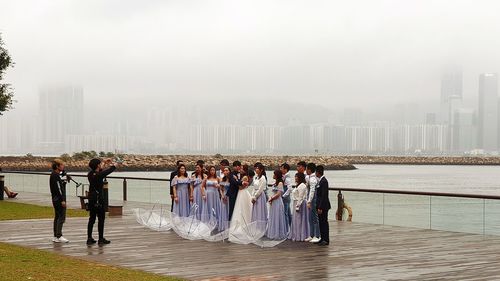 Group of people on railing against buildings in city