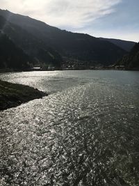 Scenic view of lake by mountains against sky