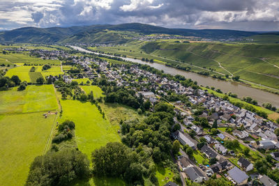 Scenic view of agricultural field by houses and trees