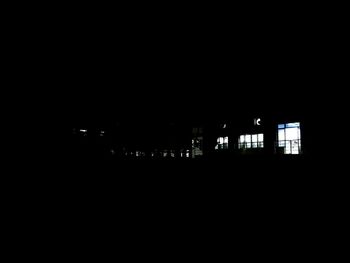 Silhouette buildings against clear sky at night