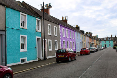 Cars on road by buildings in city