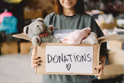 Volunteer teengirl preparing donation boxes for people.