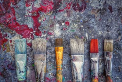 Close-up of paintbrushes arranged on old table