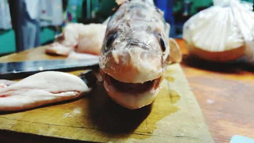 Close-up of fish on cutting board at table