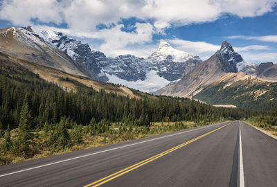 Road by mountains against sky