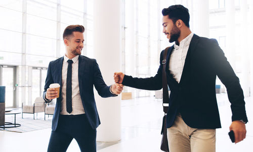 Male colleagues greeting in office