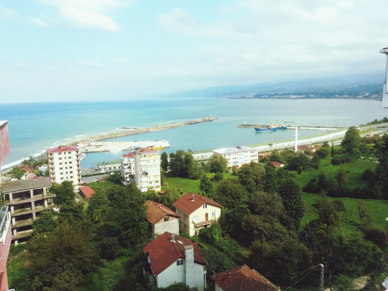 sea, sky, architecture, water, built structure, tree, building exterior, cloud - sky, horizon over water, high angle view, cloud, connection, transportation, nature, city, day, scenics, blue, cloudy, house