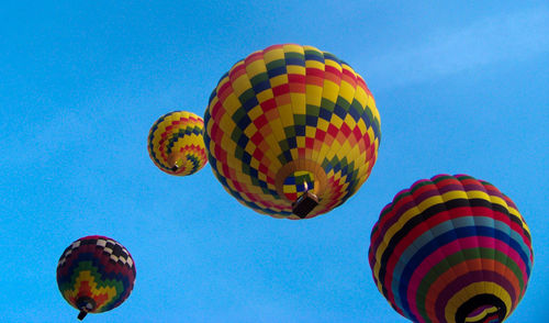 Low angle view of hot air balloons against blue sky