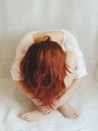 Rear view of woman sitting on floor