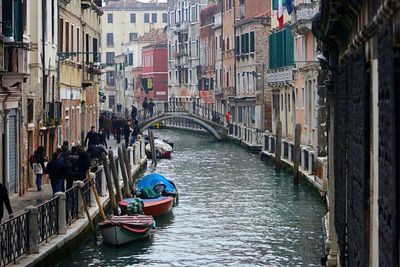 Boats in canal amidst buildings