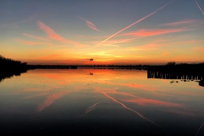 Scenic view of lake against romantic sky at sunset