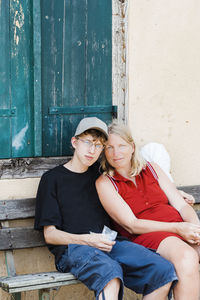 Young couple sitting against wall