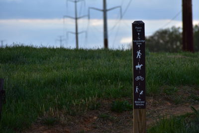 Information sign on wooden post in field