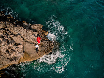 High angle view of person on rock in sea