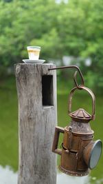 Close-up of coffee cup on wooden post