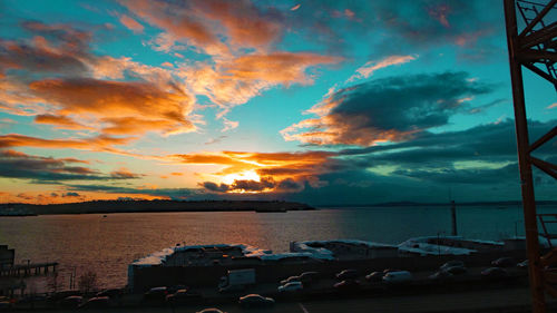 Scenic view of sea against cloudy sky at sunset