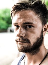 Close-up portrait of young man sweating outdoors