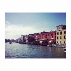 Boats in river with buildings in background