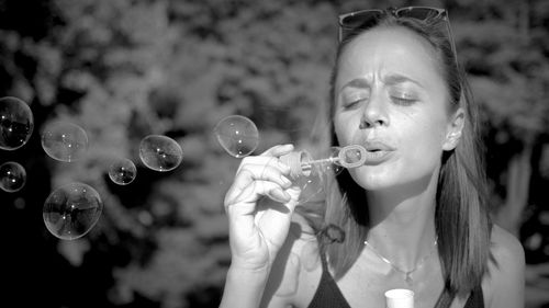 Close-up of woman playing with bubble wand