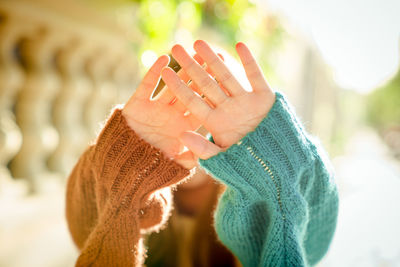 Cropped hands of person against trees