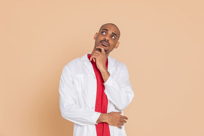 Young man looking away against white background