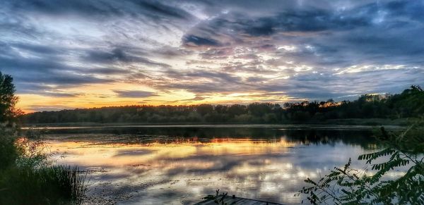 Scenic view of lake against sky at sunset