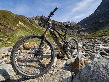 Bicycle parked on land against mountains