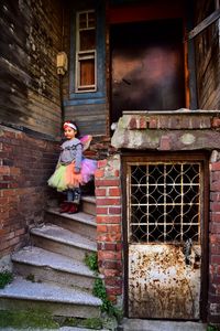 Girl wearing costume while standing on steps outside house