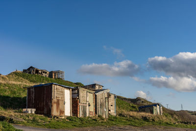 Old house on field against sky