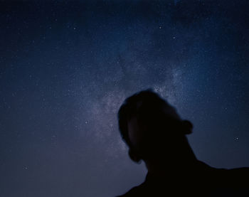 Low angle view of silhouette woman against star field