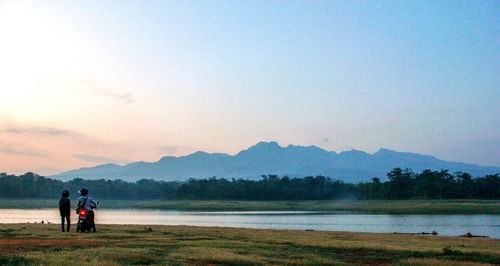 Scenic view of lake by mountains against sky