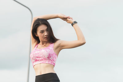 Portrait of a girl standing against sky