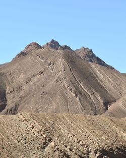 Scenic view of arid landscape against clear blue sky