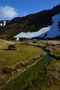 Spring day in iceland with a scenic landscape with a flowing hot spring river.