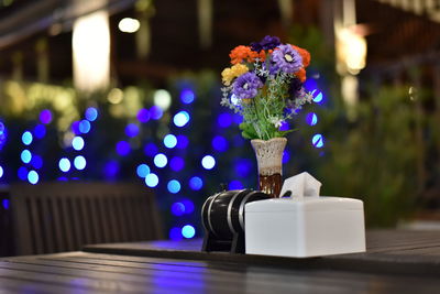 Close-up of illuminated purple flower on table