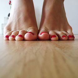 Low section of woman standing on hardwood floor