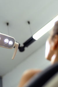 Low angle view of illuminated lighting equipment hanging from ceiling