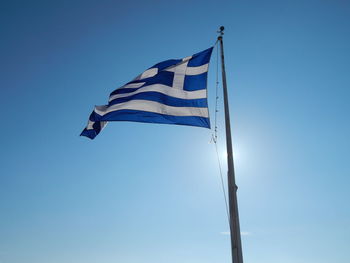 Low angle view of flag against blue sky