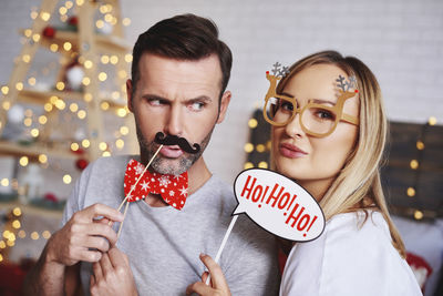 Portrait of couple with props at home during christmas